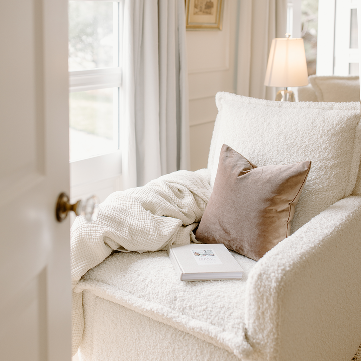 Flynn Recliner in sheepskin cloud fabric with muslin blanket, throw pillow and book